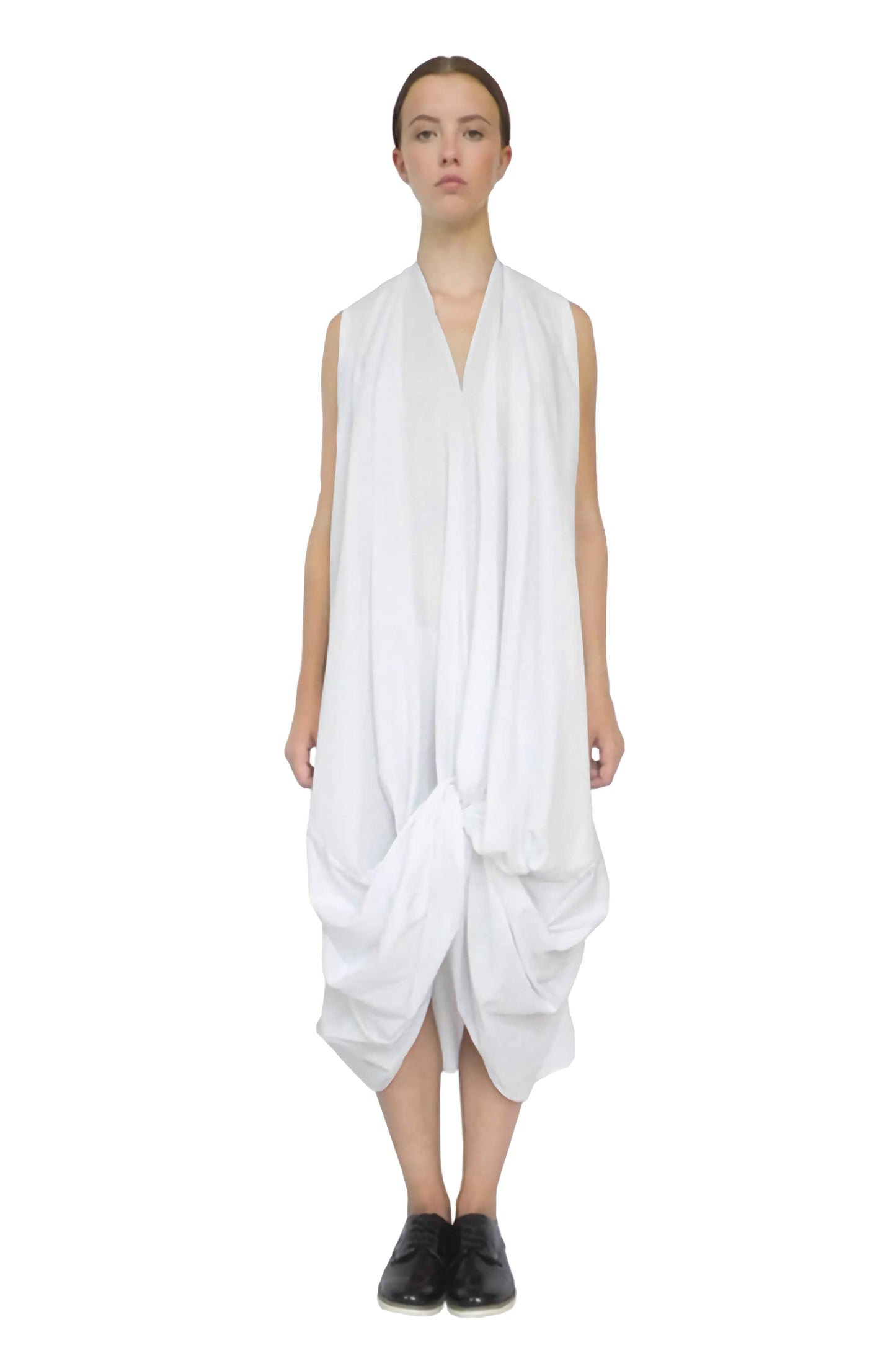 Front view of the white knotted dress with good luck knot structure draped by skilled craftsmanship into a zero waste sustainable design.