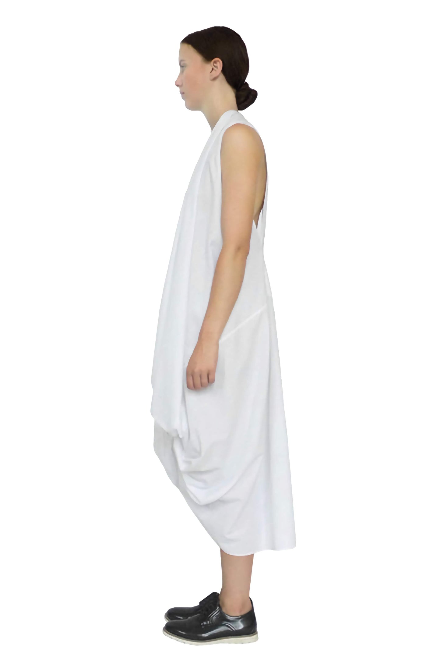 Side view of the white knotted dress created in a zero waste sustainable pattern cutting and drape fashion style.