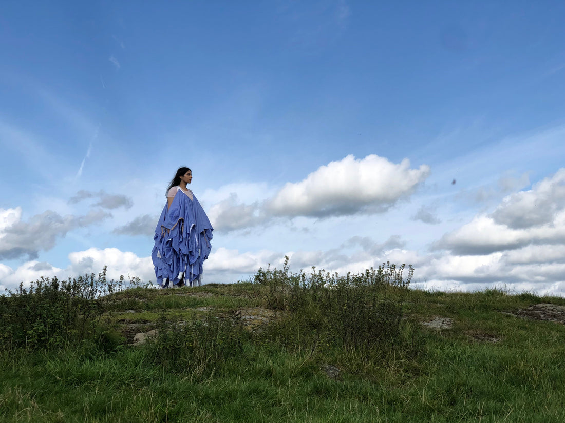 recycled ppe medical gowns made into a high end luxury dress woen by model on hill with beautiful skyline