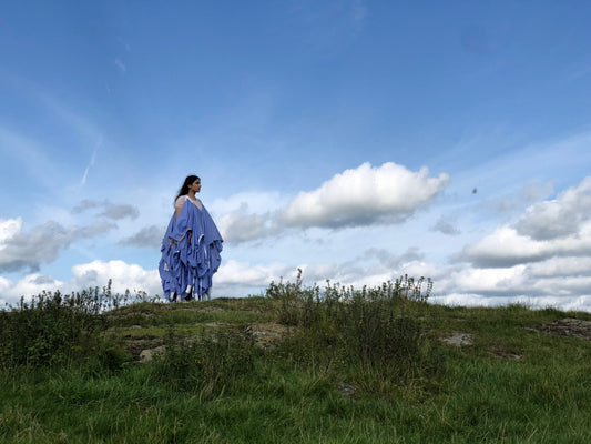 recycled ppe medical gowns made into a high end luxury dress woen by model on hill with beautiful skyline