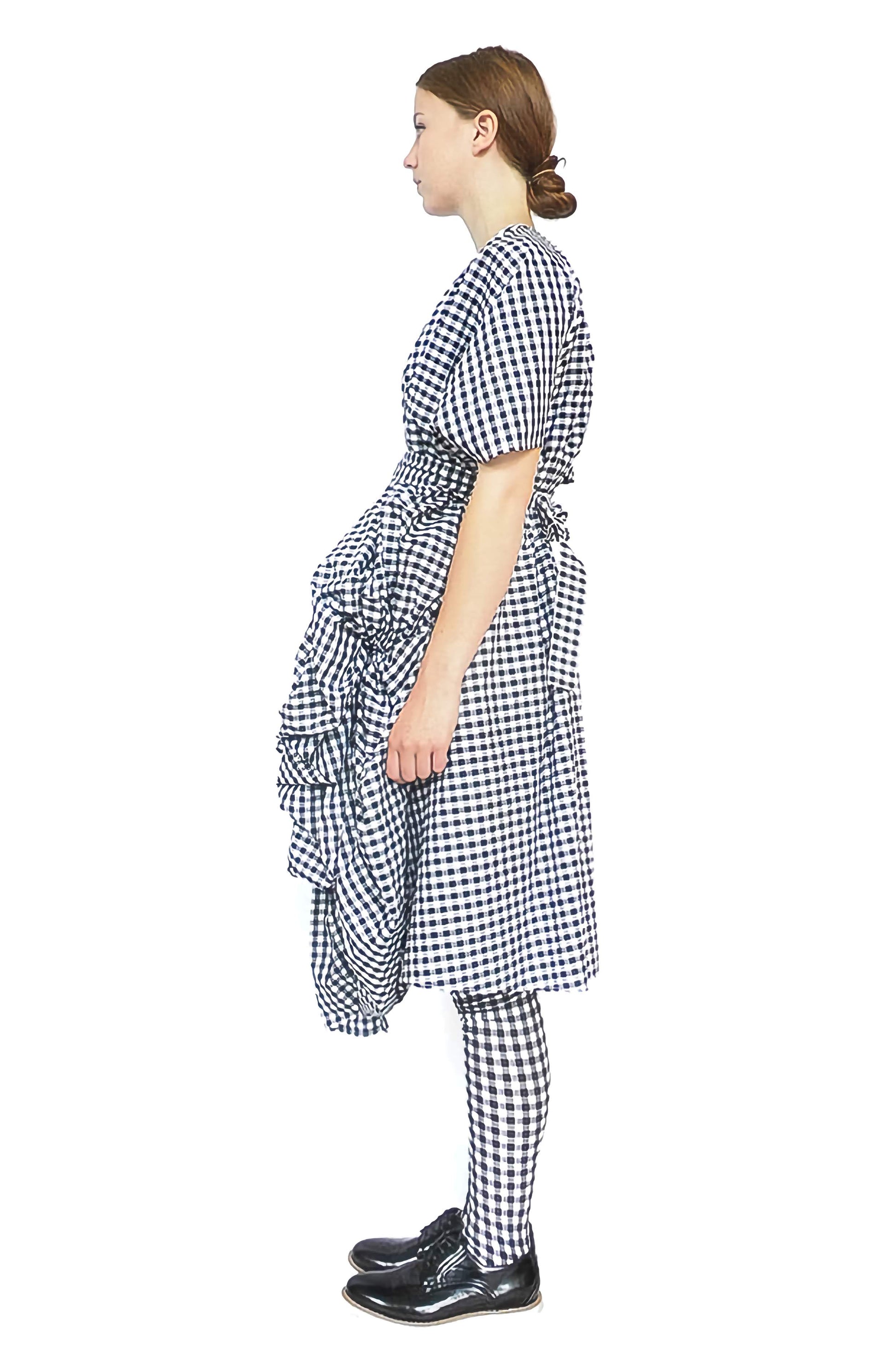 Side view of the edgy gingham cotton designer dress with voluminous front and high waisted belt.
