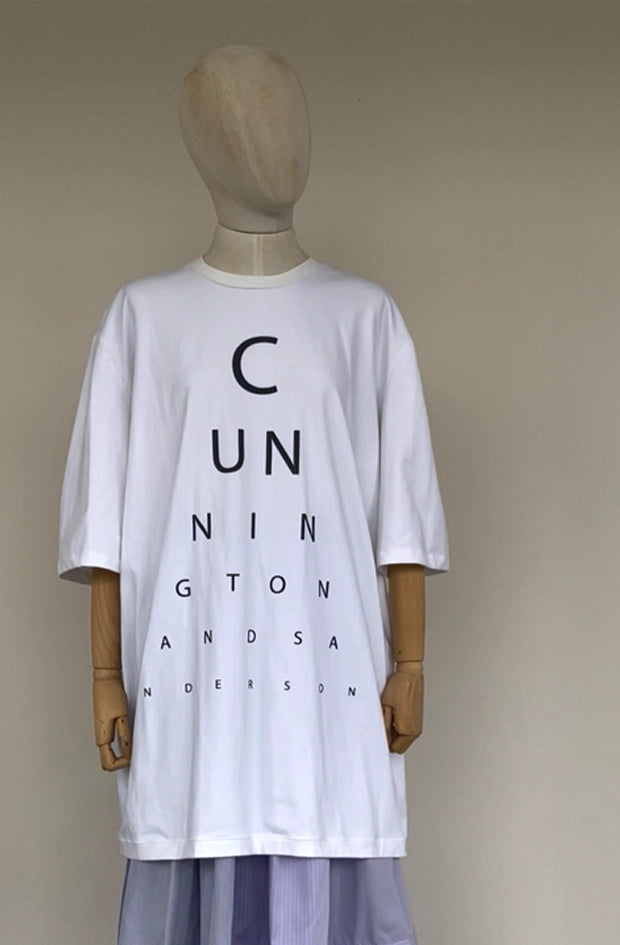 White t-shirt dress with black text reading Cunnington and Sanderson on a mannequin against a beige background