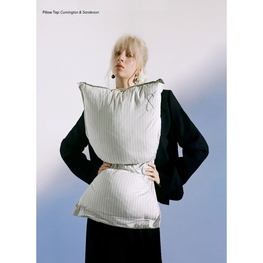 Person wearing a pillow top garment with a plain background