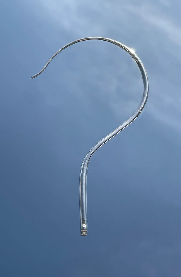 Metallic silver question mark unisex earing jewellery against a blue sky made in Paris