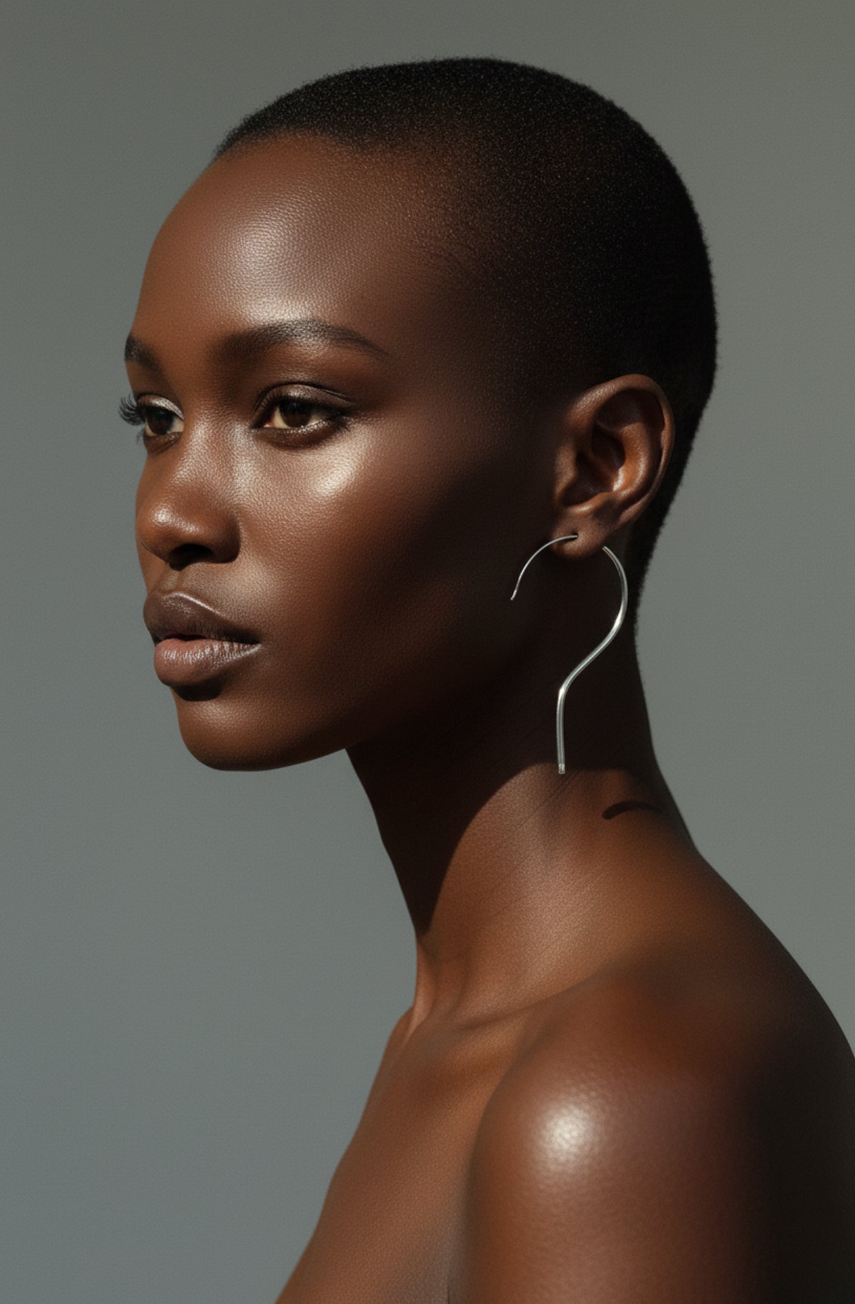 Silver hanger earring worn by model, close-up profile view — minimalist silver wire jewellery, handmade in the Paris