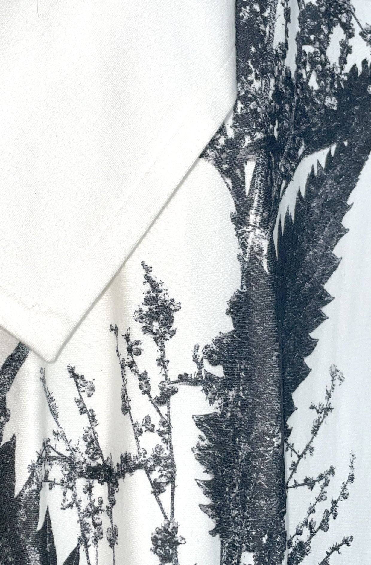 Close-up of a black nettle print pattern on white organic cotton zero waste nettle dress