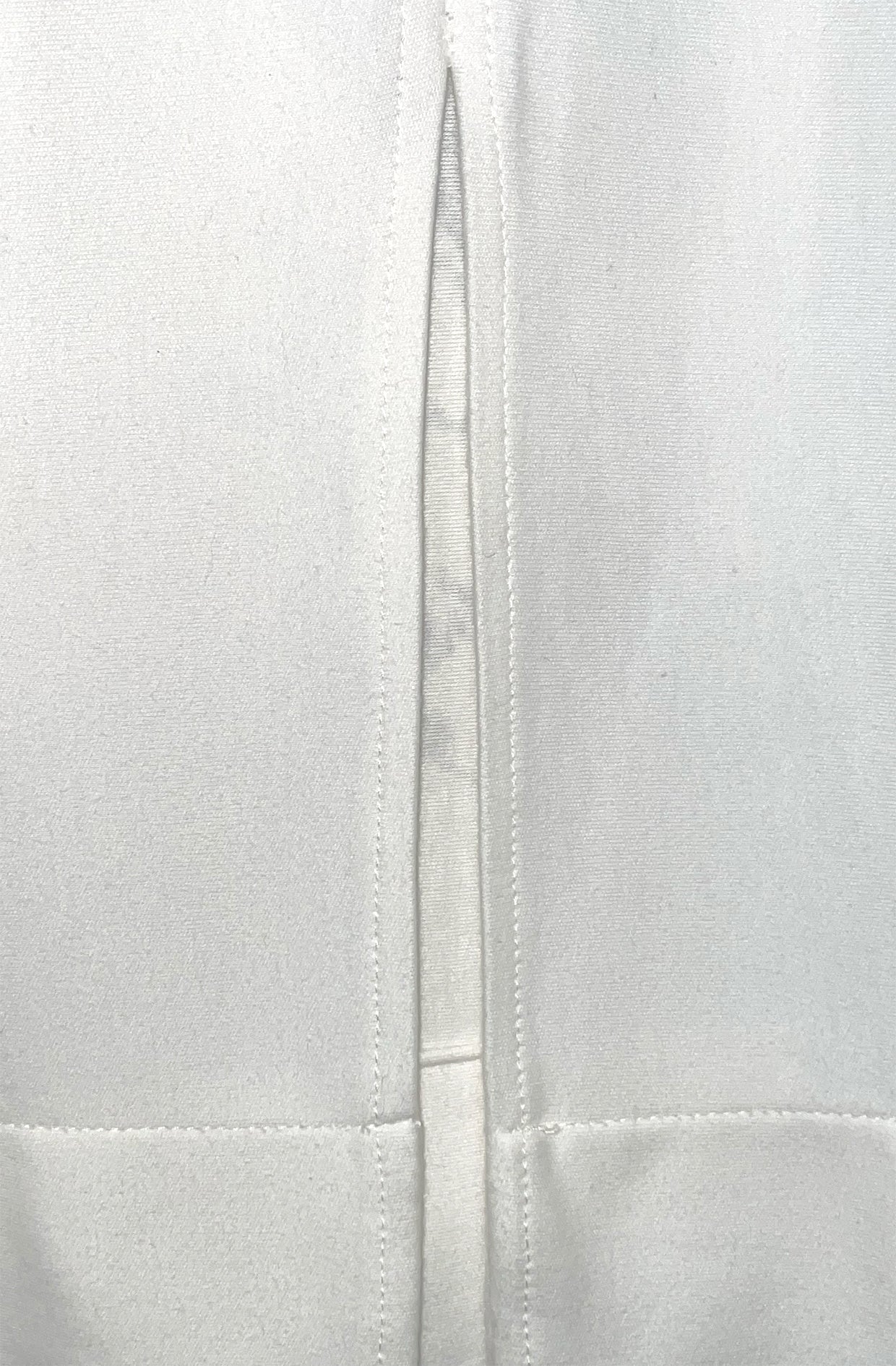Close-up of back vent detail on white organic cotton fabric texture zero waste nettle dress
