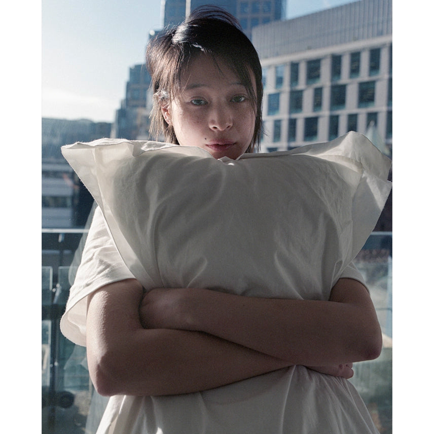 Model wearing the Pillow T-shirt against a cityscape background