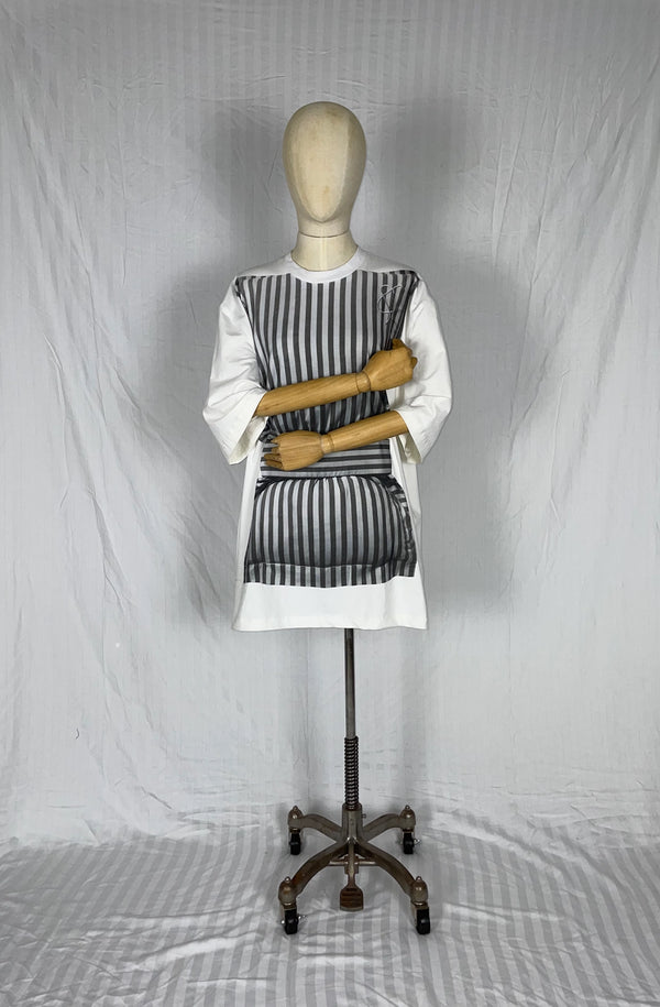 Mannequin wearing a white t-shirt dress hugging a grey striped pillow for mental health awareness
