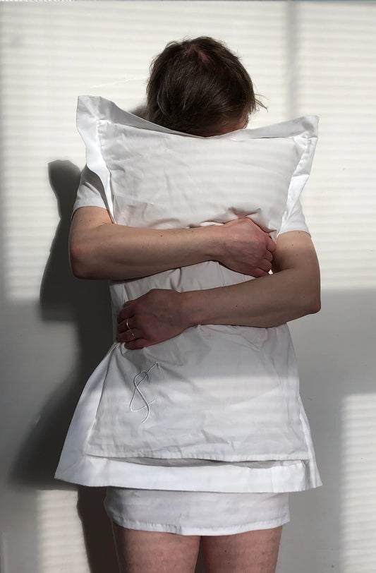 Person wearing a unisex white pillow t-shirt sustainably made in organic cotton