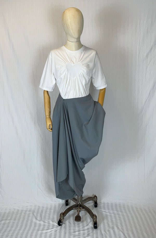 Mannequin wearing a white organic heart top and asymmetrical drape gray skirt on a white background